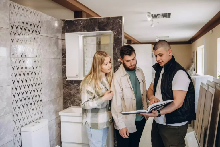 Couple Looking Tiled Bathroom. They Are In A Warehouse That Sells Interior Home And Bathroom Decoration